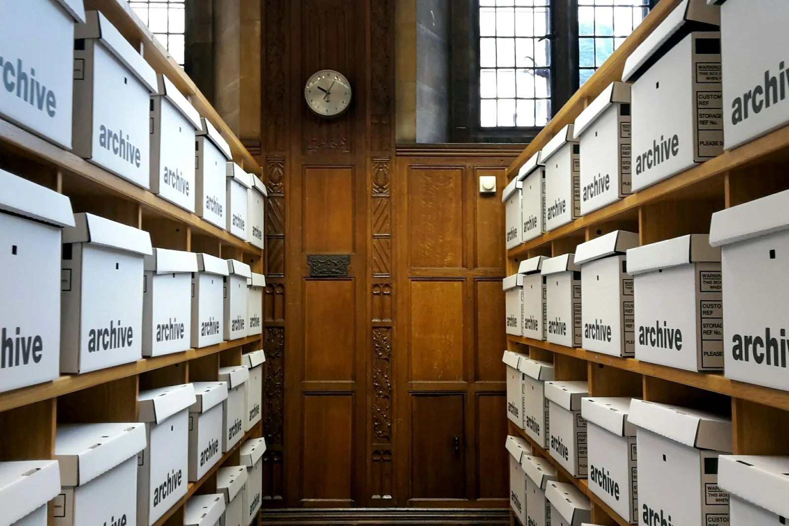 Allée bordée d’étagères remplies de boîtes d’archives soigneusement étiquetées