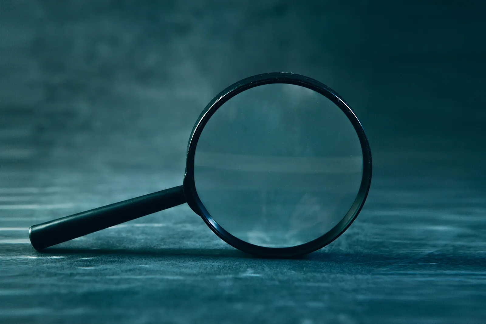 Loupe posée sur une surface bleu nuit, image de l’examen attentif des comptes